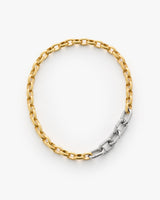 Chain necklace with mixed metal links displayed on a plain background.