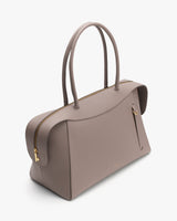 A handbag with a curved top and two handles.