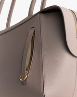 Close-up of a handbag with a zipper pocket and handles.