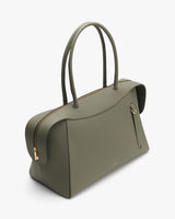 Handbag with curved top handles and a side zipper pocket.