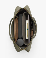 Open travel bag showing organized contents including a notebook, laptop, and small pouch.