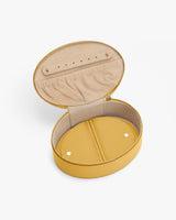 Round jewelry case with open lid and inner compartments.