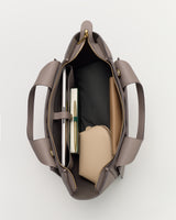 Open travel bag showing contents like books and a pouch inside.