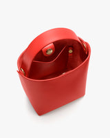 Open-top bucket bag with a handle and snap button closure.