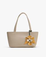 Handbag with large floral decoration and two shoulder straps.