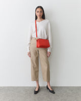 Woman wearing a crossbody bag with adjustable strap attached to the handbag.