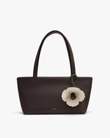 Handbag with flower decoration on handle.
