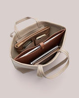 Open handbag with organized compartments and items inside.