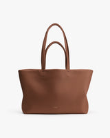 Large tote bag with minimalist design and long handles.