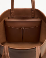Open handbag showing interior pockets and straps.