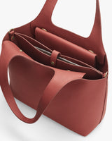 Handbag with multiple compartments and inner snap closure pocket.