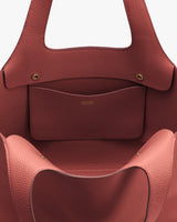 Open handbag with small internal pocket and gold button clasp details.
