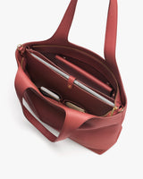 Open tote bag with laptop, sunglasses, and tablet inside.