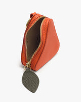 Small triangular pouch with zipper partially open and a leaf-shaped tag attached.