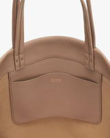 Leather handbag with double handles and a front pocket.