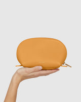 A hand holding a small pouch with a zipper.