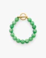 Beaded bracelet with round clasp displayed on a surface.