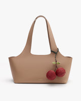 Tote bag with two round charms attached to the handle.