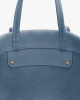 Close-up of a travel bag with two handles and button accents.