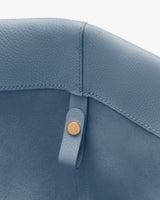 Close-up of a bag's interior seam with a snap button.