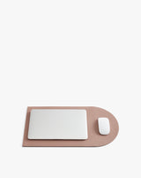 Laptop and mouse on a rounded desk mat.