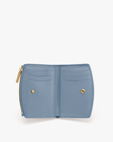 Open wallet with card slots and gold snap buttons.