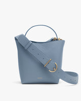 Bucket bag with a wide adjustable strap and top handle.