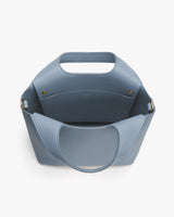 Handbag with open top and wide handles shown from above.