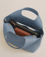 Open handbag with wallet and zippered pocket inside.