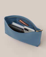 Open pouch with phone, wallet, notepad, and lipstick inside.