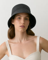 Person wearing a bucket hat and a sleeveless top.