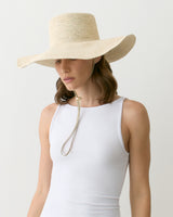 Person wearing a wide-brimmed hat and sleeveless top facing slightly sideways