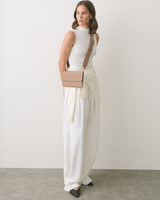 Woman in a long dress with a small shoulder bag