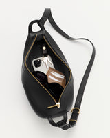 Belt bag open with keys, phone, and small pouch inside.