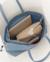 Open travel bag with purse, wallet, keys, and other items inside.