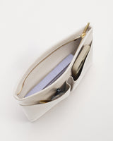 Open handbag with a phone, notebook, and pen inside.