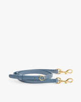 Thin strap with gold clasps on both ends laid flat.