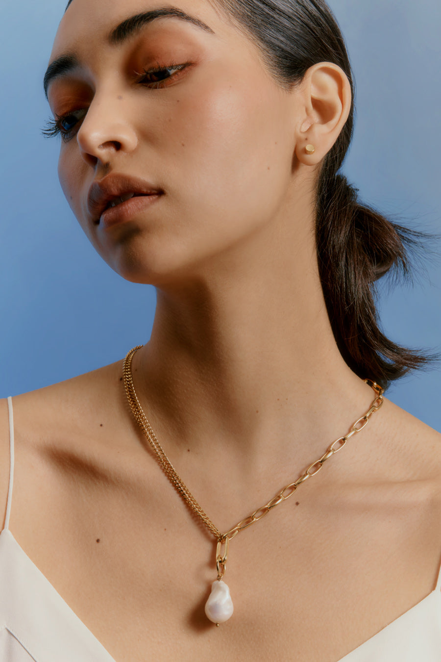 Woman with a necklace featuring a pendant.