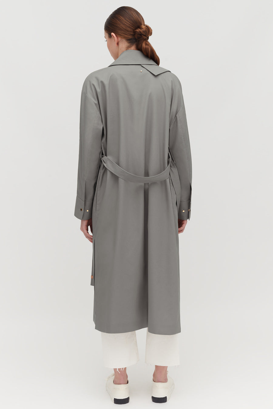 Relaxed Trench Person wearing a long coat and pants, viewed from the back.