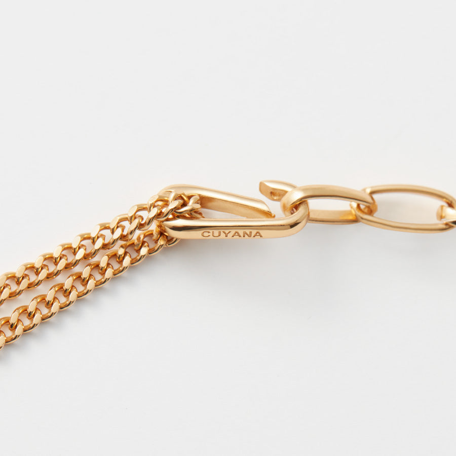 Close-up of a chain linked by a branded clasp.