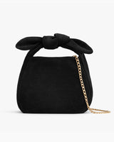 Handbag with a knotted handle and a chain strap.