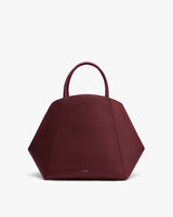 Geometric handbag with top handles in a hexagonal shape.