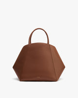Geometric-shaped handbag with short handles displayed against plain background.
