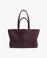A tote bag with two handles on a plain background.