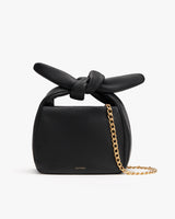 Small handbag with a tied knot and chain strap.