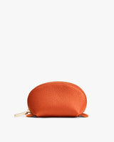Small leather zippered pouch against plain background.
