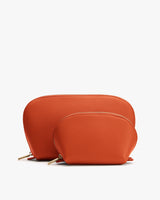 Two orange pouches with zip closures, one larger, one smaller, placed side by side.