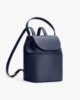 Backpack with a flap top and adjustable strap standing upright