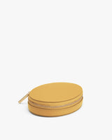 Small round zippered case on a plain background