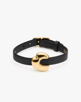 Black bracelet with gold-tone clasp on white background